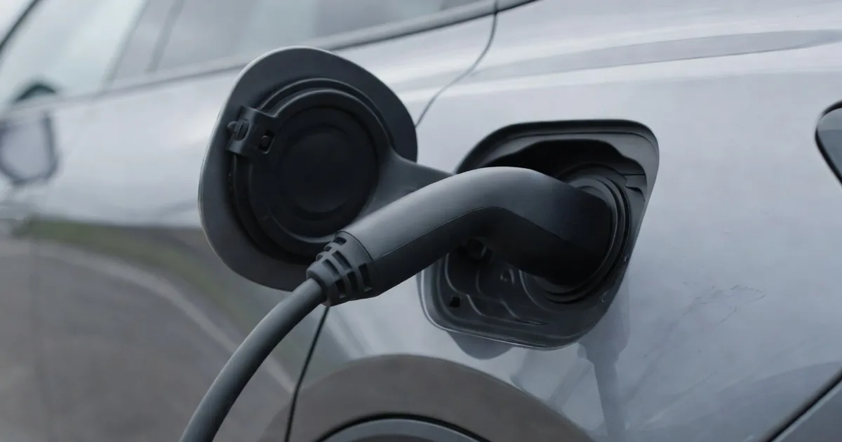 A charging cable arcing from an unbranded blank fast charger to the side of an electric car