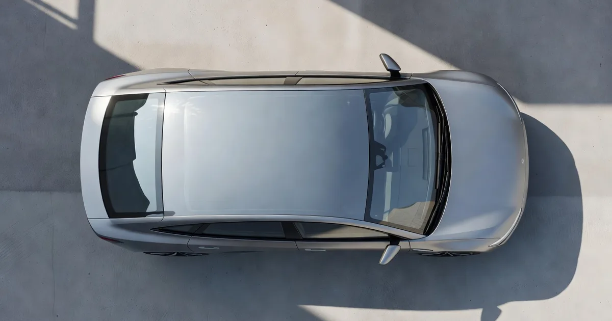 Top-down view of an electric car roof and panoramic glass parked on light concrete